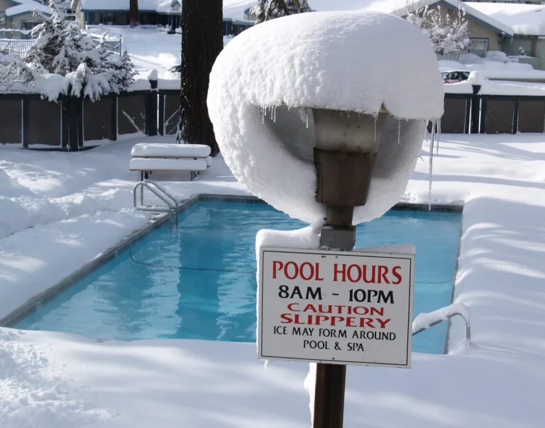 iStock-173857017-Snow-covers-the-ground-around-a-swimming-pool-and-a-sign-with-pool-hours-is-topped-with-snow