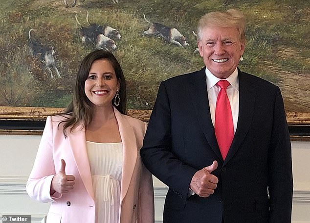 Elise Stefanik, standing with an American flag in the background, speaking passionately at a podium. She emphasizes policies that prioritize American workers, strong borders, and fair wages, in alignment with Trump's 'America First' agenda